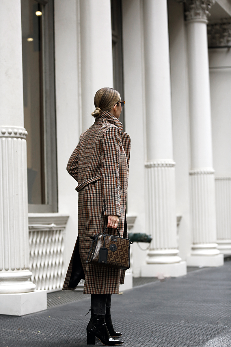 back details of woman wearing her Favorite Plaid Coat and in all black top and jeans 