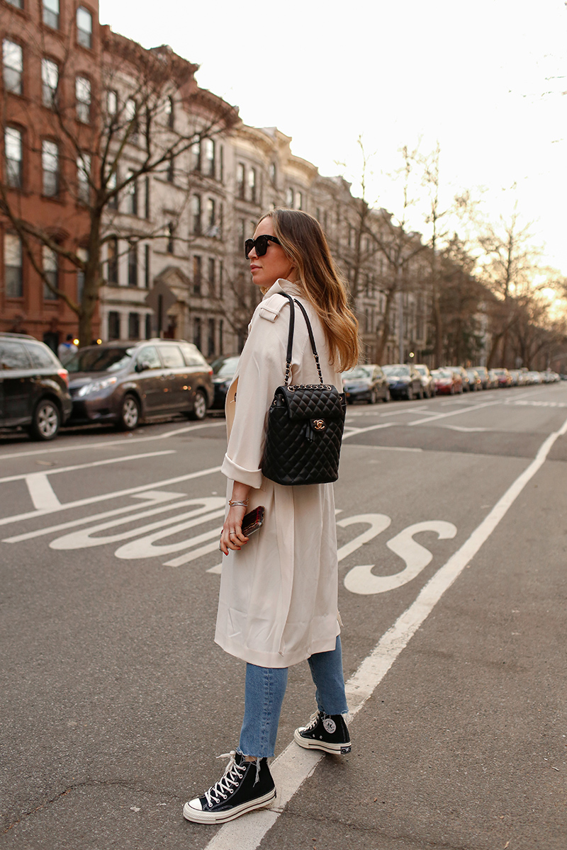 womans back wearing trench coat and jeans